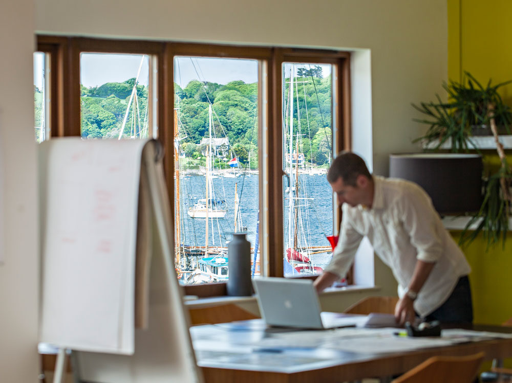 Looking at laptop with river view in the background